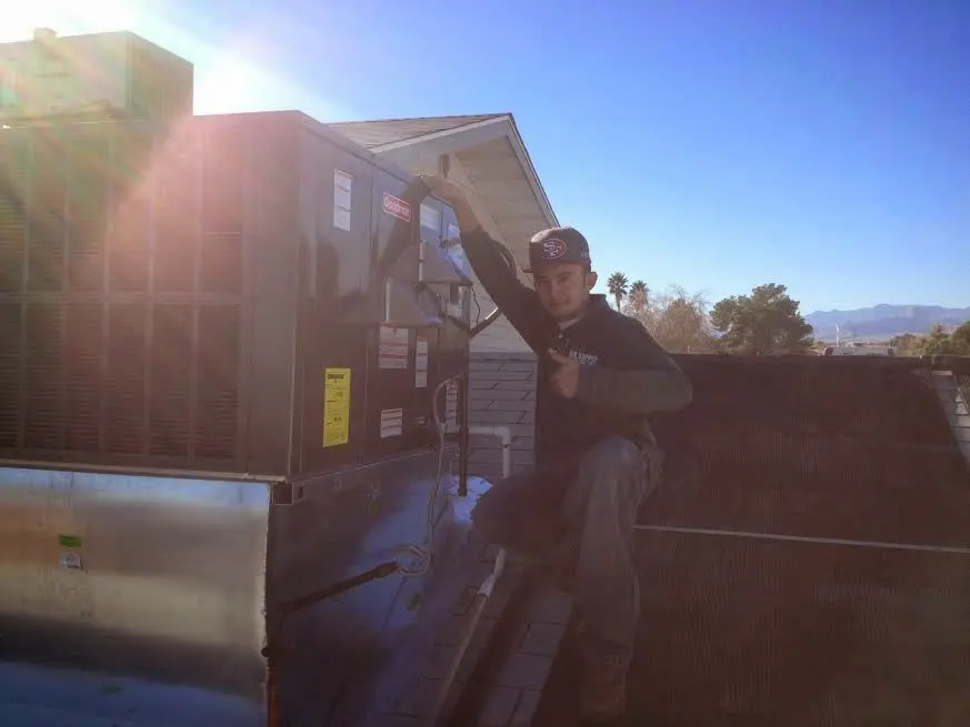 HVAC technician performing Air Duct Repair on a rooftop unit in Denville